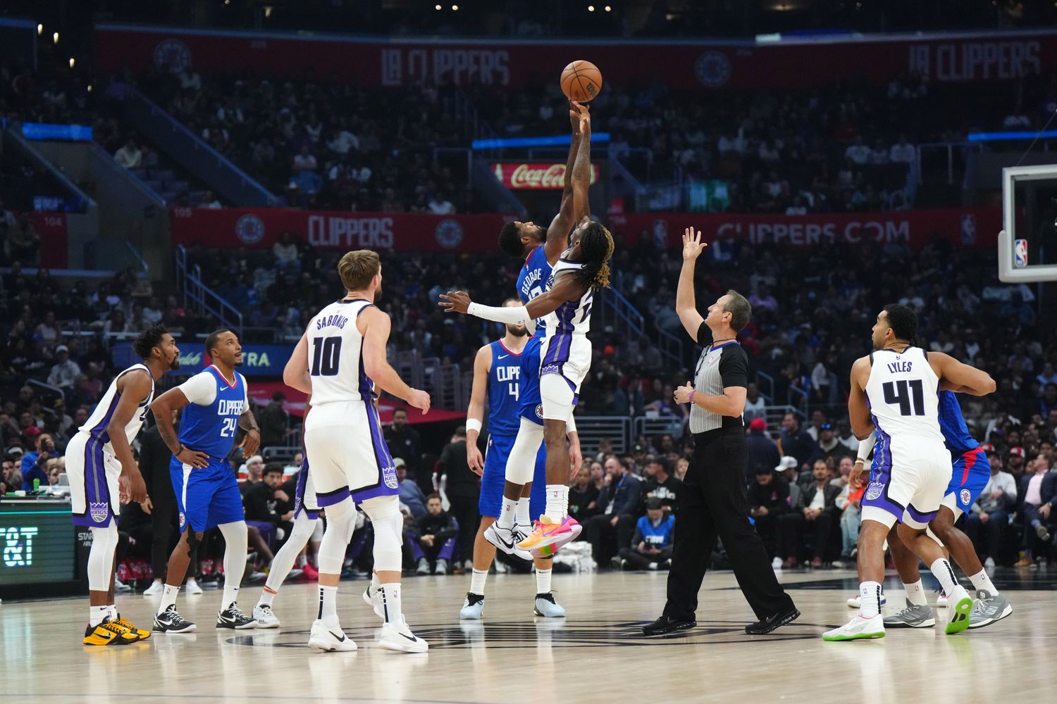 Dec 6, 2023; Los Angeles, California, USA; A jump ball between LA Clippers forward Paul George (13) and Sacramento Kings guard Keon Ellis (23) in the first half at Crypto.com Arena. Mandatory Credit: Kirby Lee-USA TODAY Sports